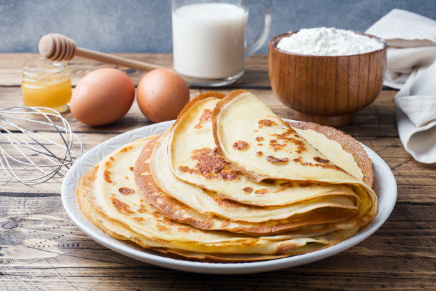 thin-pancakes-plate-wooden-background-ingredients-cooking-eggs-milk-flour_78677-179